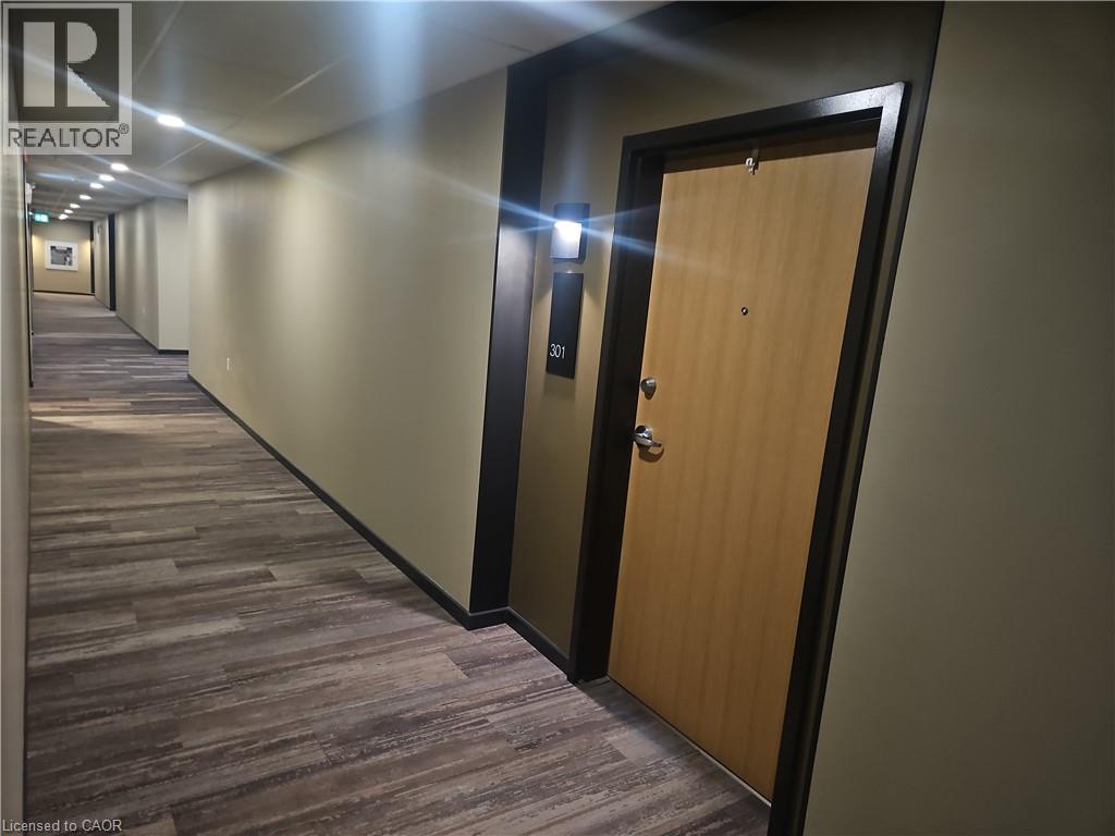 Hallway with dark wood-style flooring and recessed lighting - 249 Grey Silo Road Unit# 301, Waterloo, ON - Indoor Photo Showing Other Room