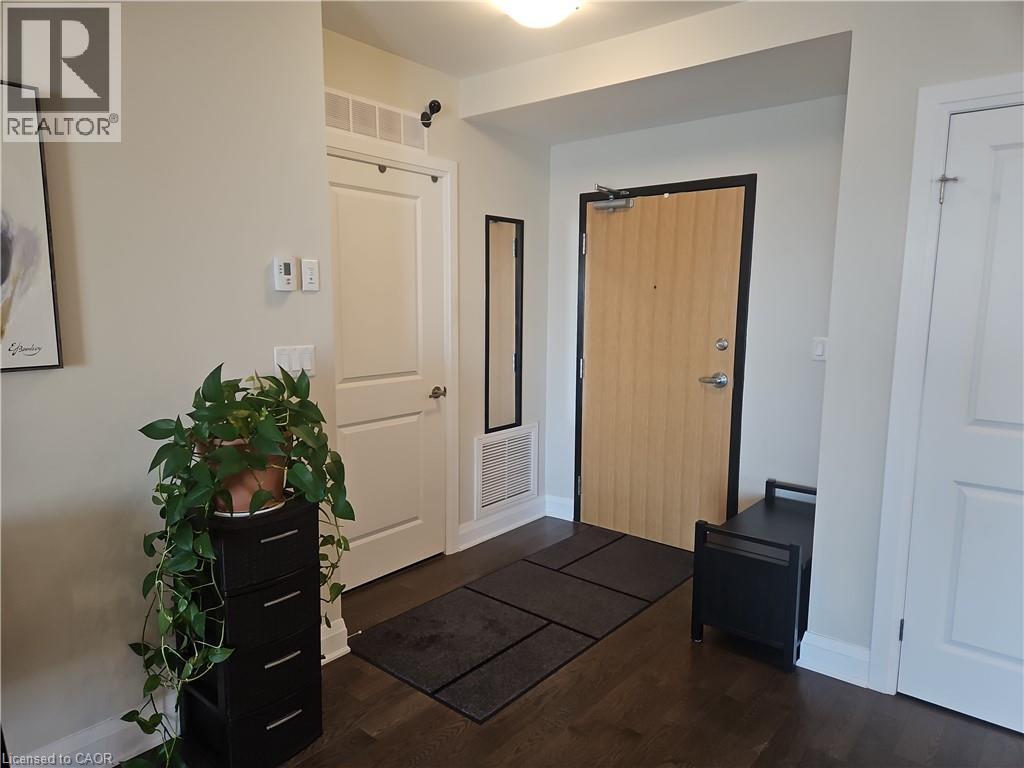 Entrance foyer with dark wood-style flooring and baseboards - 249 Grey Silo Road Unit# 301, Waterloo, ON - Indoor Photo Showing Other Room