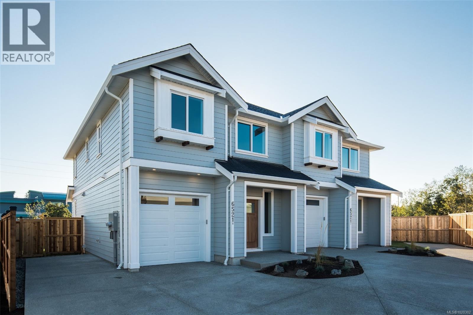 View of front facade with an attached garage, concrete driveway, and a shingled roof - A 6521 Noblewood Pl, Sooke, BC - Outdoor