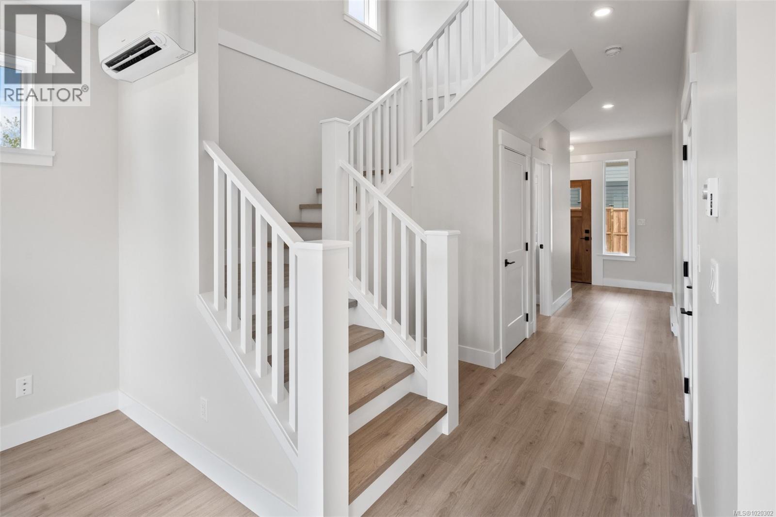 Stairs with wood finished floors and a wall mounted air conditioner - A 6521 Noblewood Pl, Sooke, BC - Indoor Photo Showing Other Room
