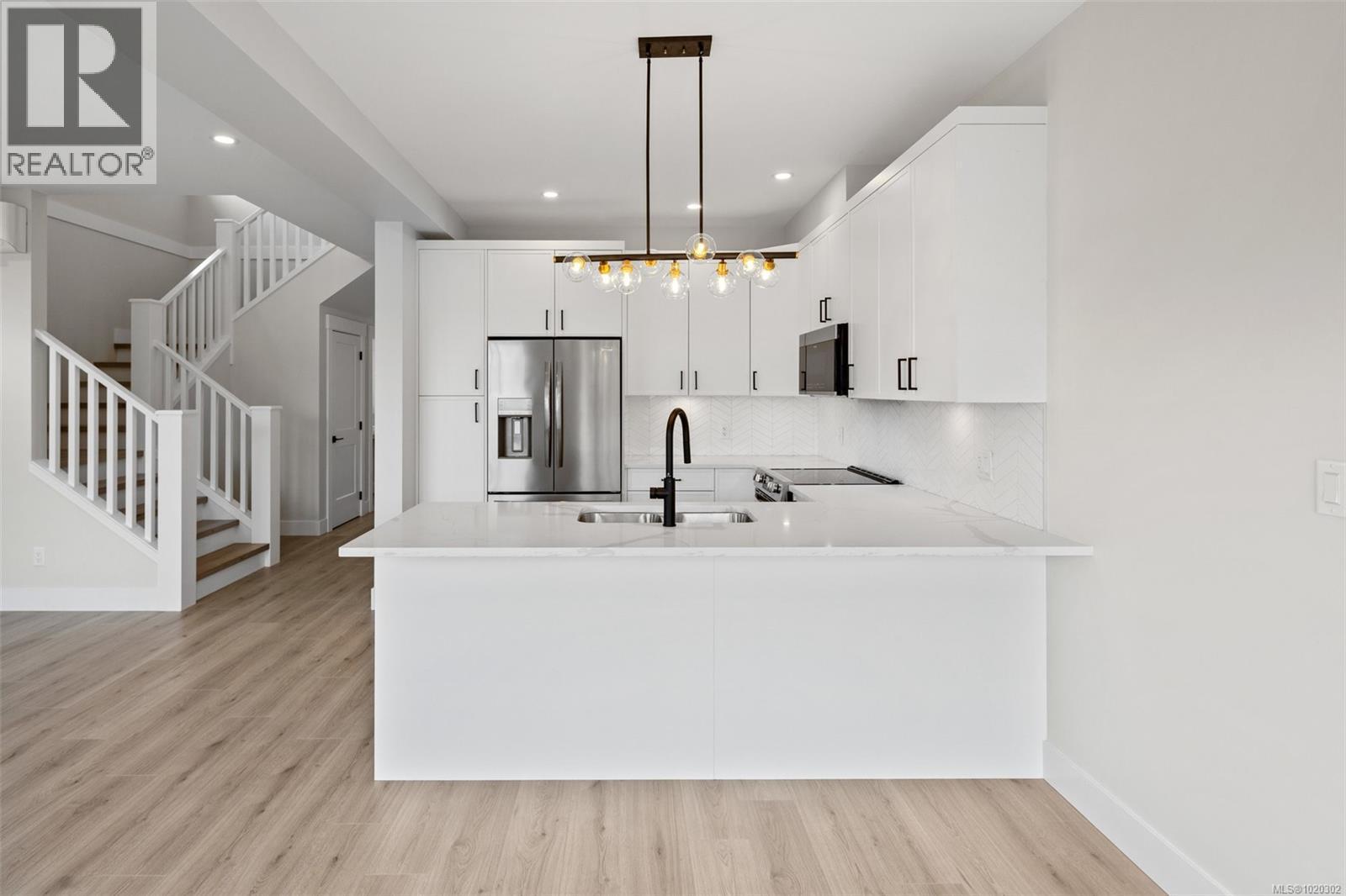Kitchen featuring white cabinets, backsplash, pendant lighting, light wood-style floors, and recessed lighting - A 6521 Noblewood Pl, Sooke, BC - Indoor Photo Showing Kitchen