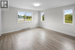 Unfurnished room with a baseboard heating unit and light wood-style flooring -