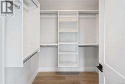 Spacious closet featuring wood finished floors -