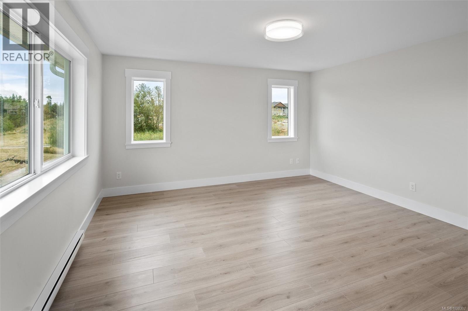 Empty room featuring a baseboard heating unit and light wood-style floors - A 6521 Noblewood Pl, Sooke, BC - Indoor Photo Showing Other Room