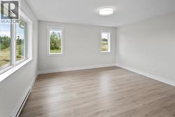 Empty room featuring a baseboard heating unit and light wood-style floors -