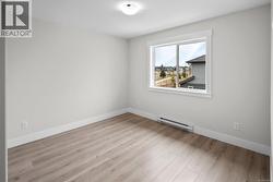Empty room featuring a baseboard radiator and light wood-style floors -