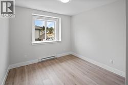 Unfurnished room with baseboard heating and light wood-style floors -