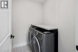 Laundry room featuring baseboards and washing machine and dryer -