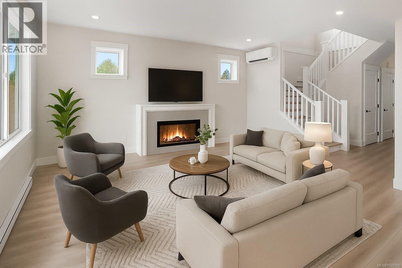 Living area with baseboard heating, light wood-style flooring, stairs, a glass covered fireplace, and recessed lighting - A 6521 Noblewood Pl, Sooke, BC - Indoor Photo Showing Living Room With Fireplace