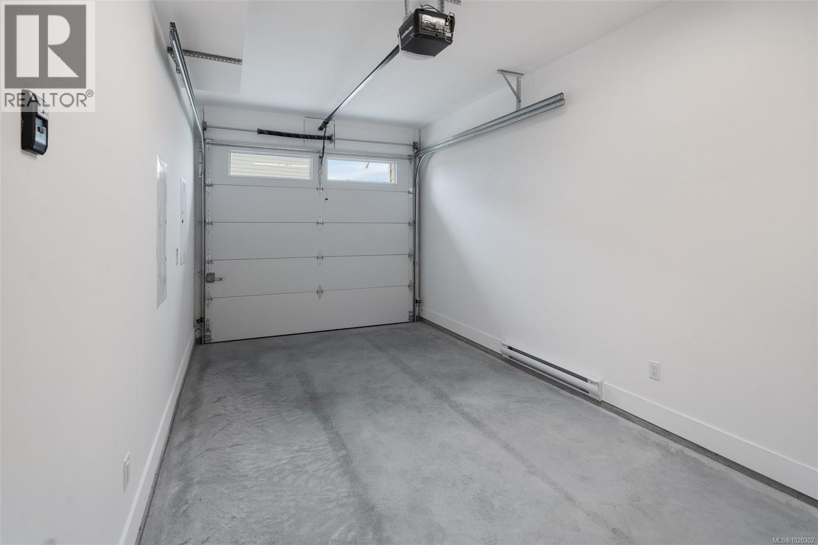Garage featuring a garage door opener and a baseboard radiator - A 6521 Noblewood Pl, Sooke, BC - Indoor Photo Showing Garage