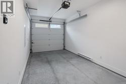 Garage featuring a garage door opener and a baseboard radiator -