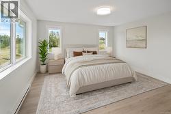 Bedroom with a baseboard heating unit and light wood-style flooring -