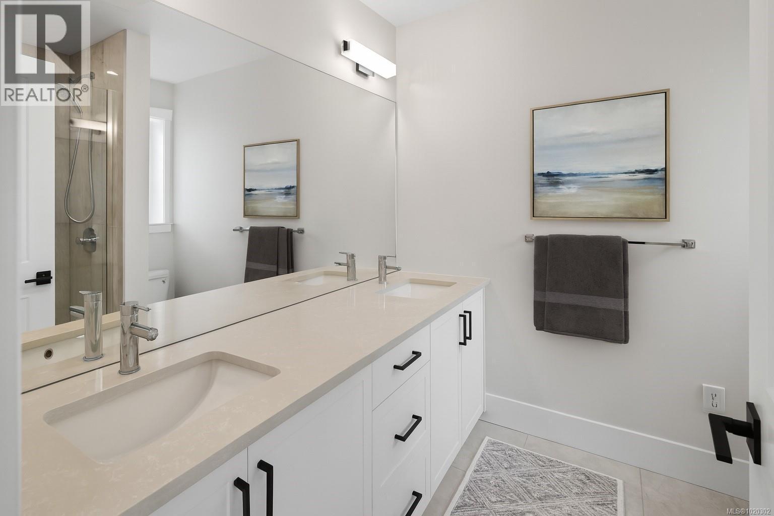 Full bath featuring a shower stall, double vanity, and light tile patterned flooring - A 6521 Noblewood Pl, Sooke, BC - Indoor Photo Showing Bathroom