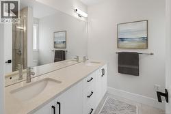 Full bath featuring a shower stall, double vanity, and light tile patterned flooring -