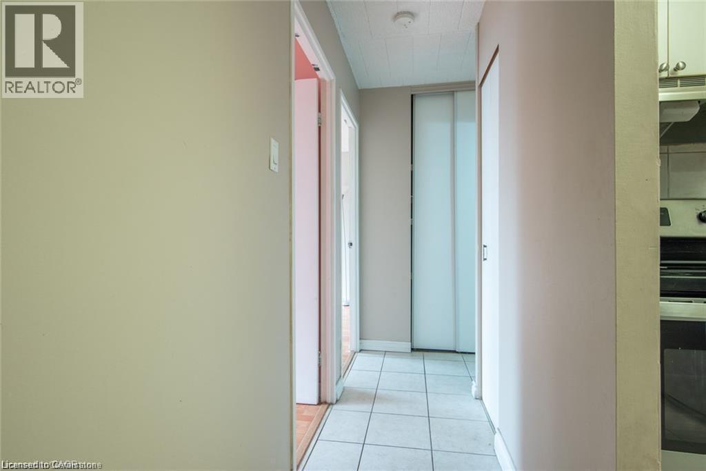 Corridor featuring light tile patterned floors and baseboards - 71 Vanier Drive Unit# 211, Kitchener, ON - Indoor