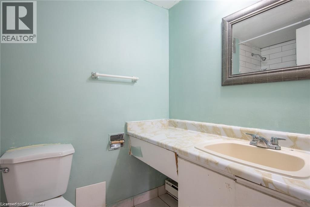 Bathroom featuring vanity, a baseboard heating unit, a shower, and light tile patterned floors - 71 Vanier Drive Unit# 211, Kitchener, ON - Indoor Photo Showing Bathroom