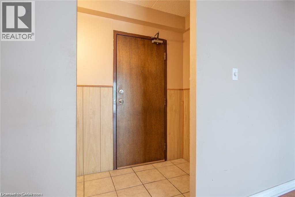 Hallway featuring wainscoting, light tile patterned floors, and wooden walls - 71 Vanier Drive Unit# 211, Kitchener, ON - Indoor Photo Showing Other Room