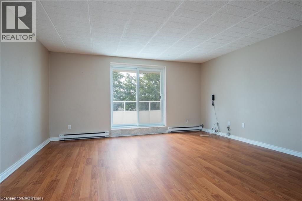 Unfurnished room with light wood-style flooring and a baseboard heating unit - 71 Vanier Drive Unit# 211, Kitchener, ON - Indoor Photo Showing Other Room