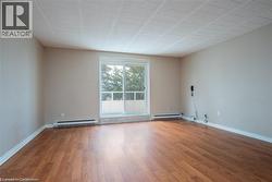 Unfurnished room with light wood-style flooring and a baseboard heating unit -