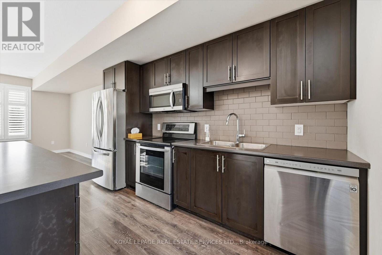 Stylish Kitchen Features a Designer Backsplash - 85 Esplanade Lane, Grimsby, ON - Indoor Photo Showing Kitchen With Stainless Steel Kitchen With Double Sink