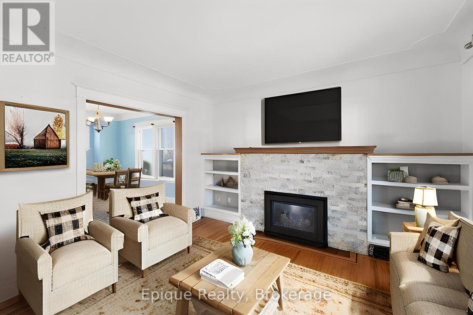 Virtually staged living room - 67 Kensington Avenue S, Hamilton, ON - Indoor Photo Showing Living Room With Fireplace