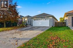View of front of property with driveway, brick siding, and an attached garage -