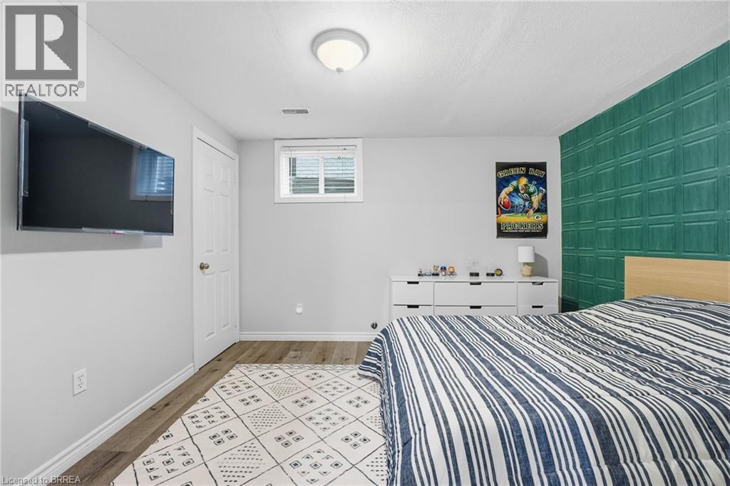 Bedroom featuring light wood finished floors and an accent wall - 14 Dunton Lane, Paris, ON - Indoor Photo Showing Bedroom