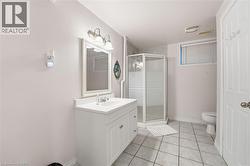 Full bathroom with vanity, light tile patterned floors, and a shower stall -