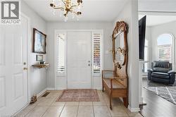 Foyer with plenty of natural light, a chandelier, and light tile patterned floors -