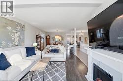 Living room featuring a premium fireplace, dark wood-type flooring, and a chandelier -