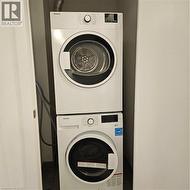 Clothes washing area with stacked washing maching and dryer -