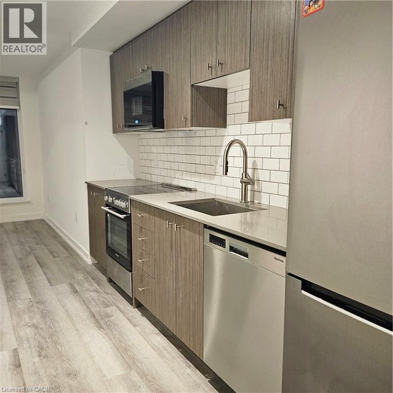 Kitchen featuring dishwasher, stove, refrigerator, sink, and tasteful backsplash - 5 Wellington Street S Unit# 703, Kitchener, ON - Indoor Photo Showing Kitchen