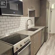 Kitchen with sink, dishwasher, fridge, decorative backsplash, and range -
