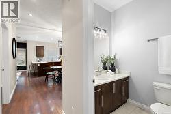 Bathroom with vanity, a textured ceiling, recessed lighting, and light wood finished floors -