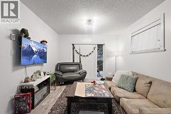 Living room with wood finished floors and a textured ceiling -