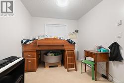 Home office with light carpet and a textured ceiling -