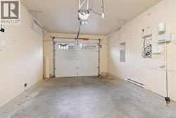 Garage with baseboard heating, electric panel, and a garage door opener -