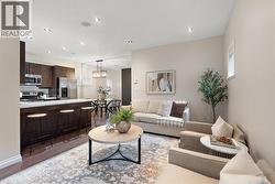 Living room with light wood-type flooring, recessed lighting, and a textured ceiling -