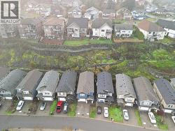 Aerial view of property and surrounding area featuring nearby suburban area -