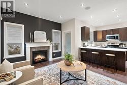 Living area with a tile fireplace, light wood-style flooring, and recessed lighting -