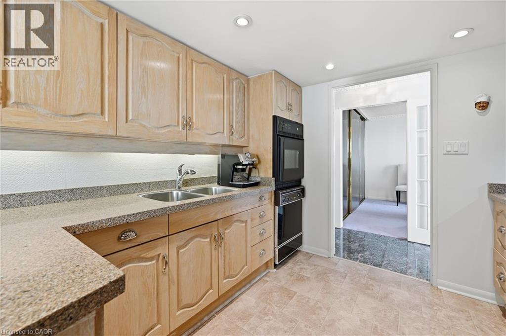 Kitchen featuring light brown cabinets, black appliances, light stone countertops, and recessed lighting - 2170 Marine Drive Unit# 1808, Oakville, ON