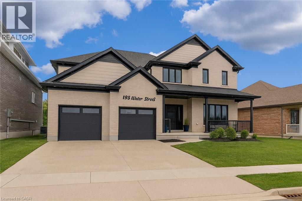 Craftsman-style house featuring covered porch, brick siding, a front yard, driveway, and a garage - 195 Water Street, St. Jacobs, ON - Outdoor With Facade