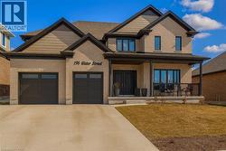 Craftsman house with brick siding, covered porch, driveway, and a front lawn -