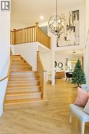 Stairs featuring hardwood / wood-style flooring, a chandelier, and a towering ceiling -