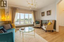 Sitting room with wood finished floors, a wainscoted wall, a water view, and a chandelier -