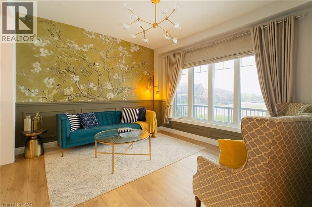 Living area featuring a decorative wall, a chandelier, hardwood / wood-style flooring, and wainscoting - 195 Water Street, St. Jacobs, ON - Indoor