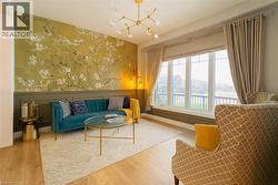 Living area featuring a decorative wall, a chandelier, hardwood / wood-style flooring, and wainscoting -