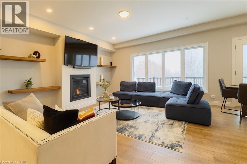 Living area with light wood-style flooring, a glass covered fireplace, and recessed lighting - 195 Water Street, St. Jacobs, ON - Indoor Photo Showing Living Room With Fireplace