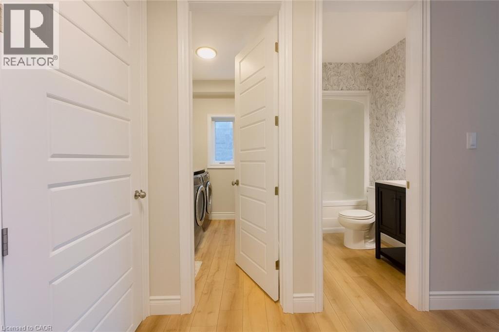 Corridor with washing machine and clothes dryer and light wood-style flooring - 195 Water Street, St. Jacobs, ON - Indoor