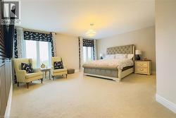 Bedroom with carpet flooring and multiple windows -